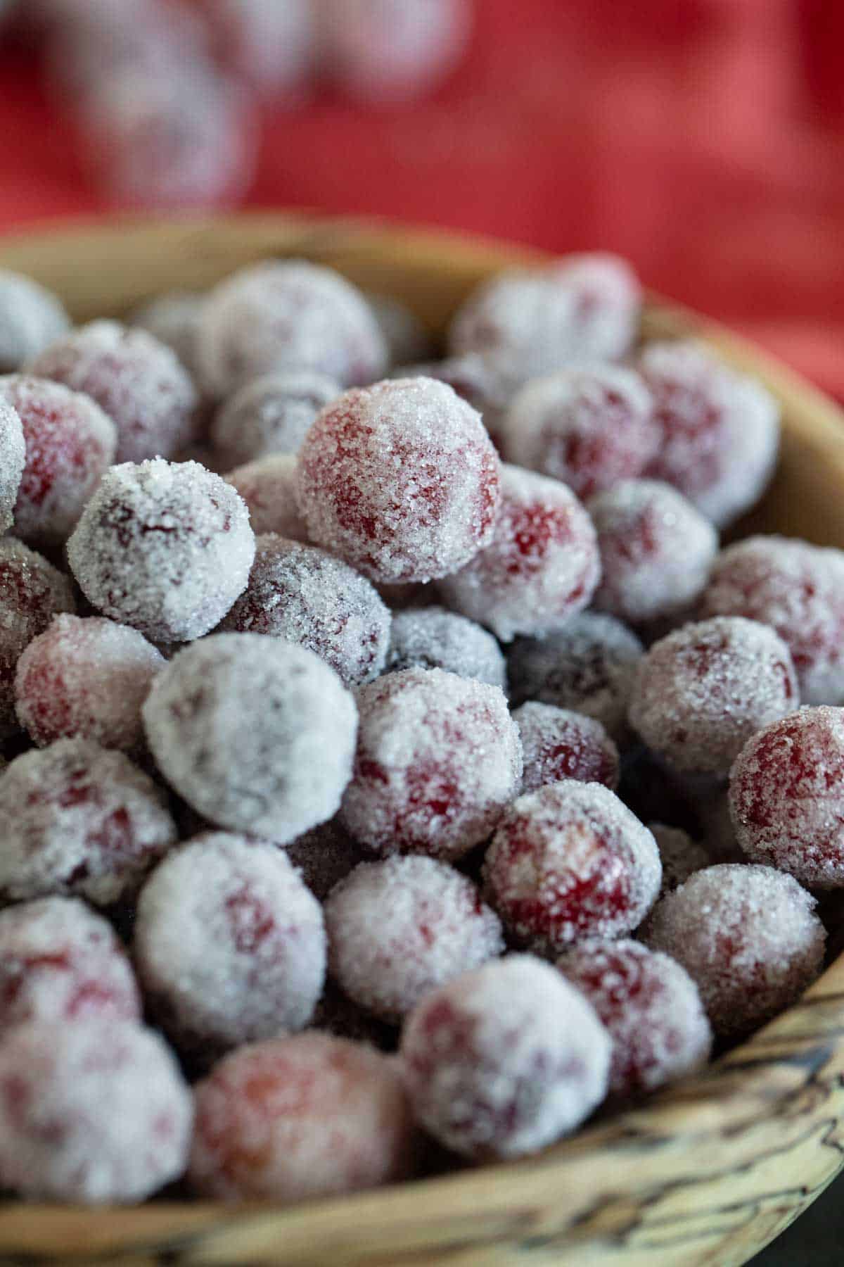 Sugared cranberries in a wooden bowl.