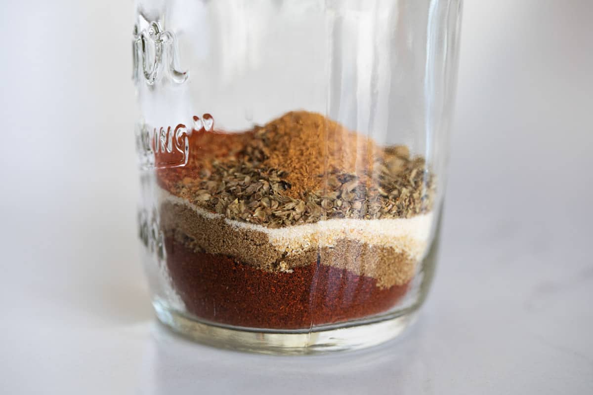 Spices layered on top of each other in a jar.