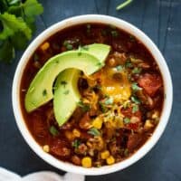 Taco Soup Recipe in a bowl topped with slices of avocados.