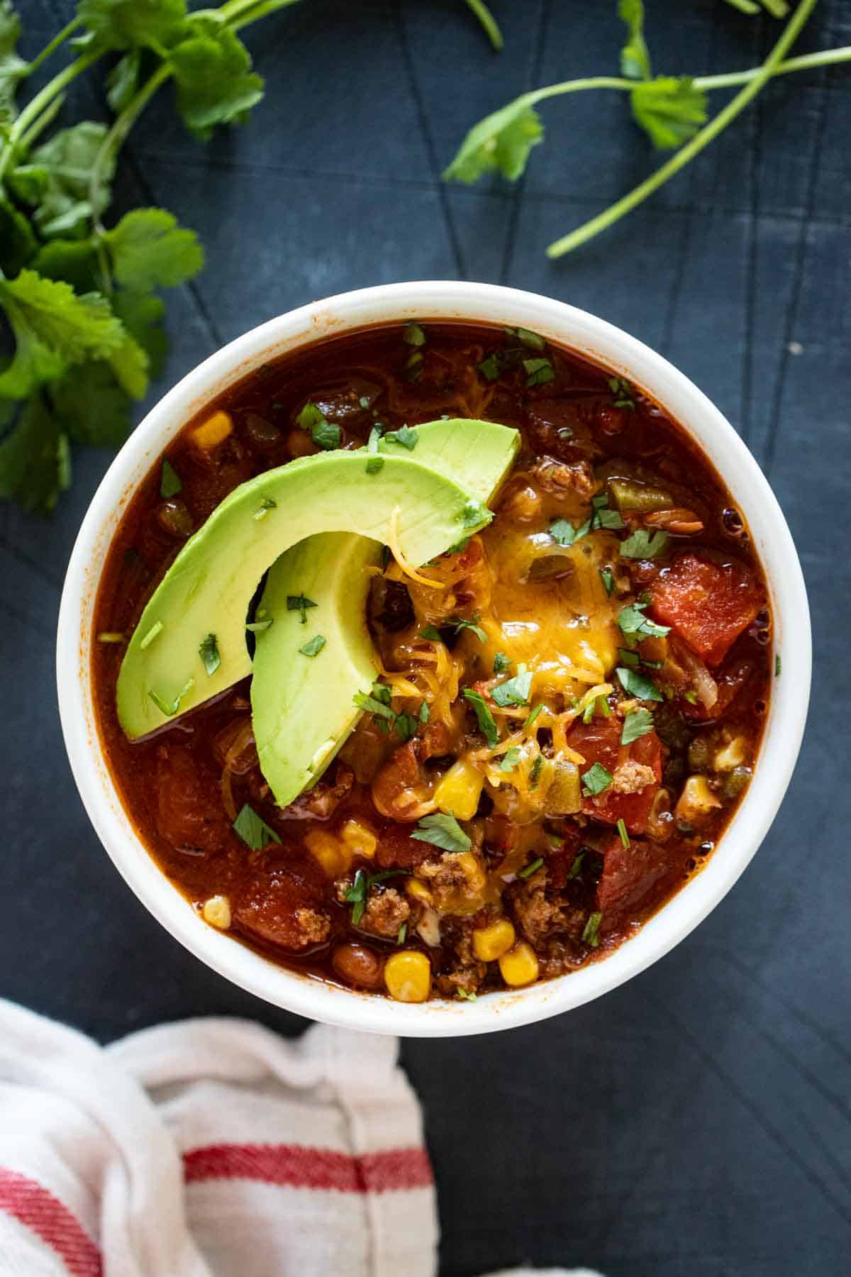 Taco Soup Recipe in a bowl topped with slices of avocados.