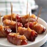Bacon Wrapped Smokies with toothpicks on a plate.