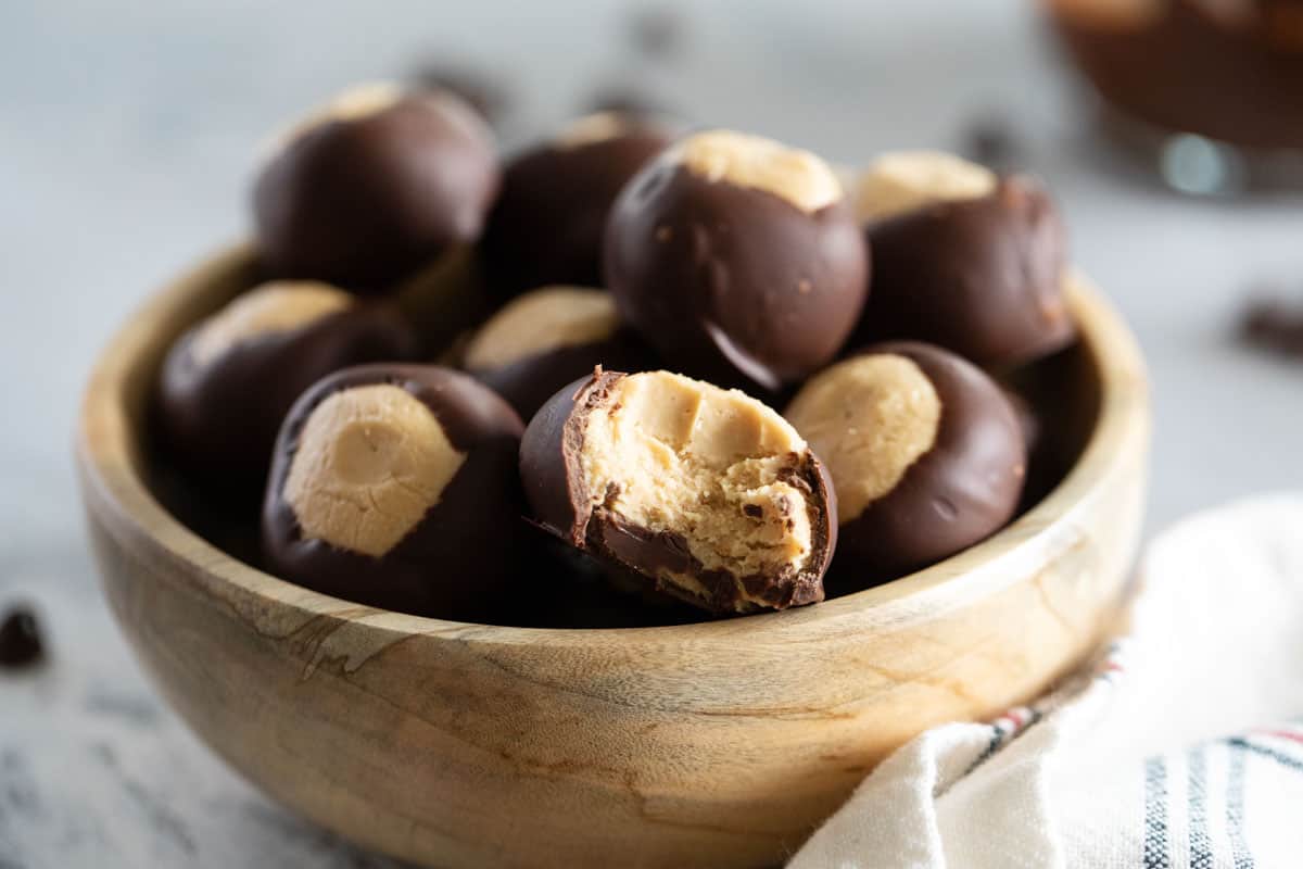 Bowl of buckeye candy with a bite taken from one.