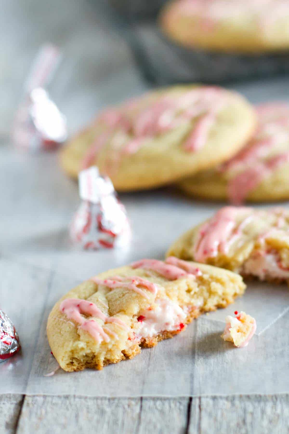 Candy cane kiss stuffed pudding cookie broken in half to show peppermint kiss in the center.