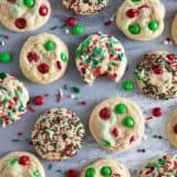 Christmas M&M Cookies on a surface with a bite taken out of one cookie.