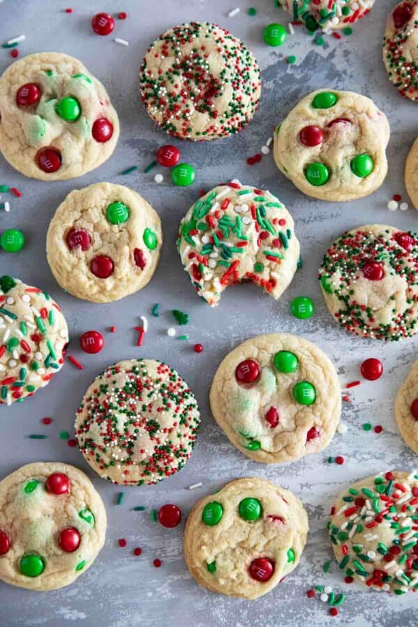 Christmas M&M Cookies on a surface with a bite taken out of one cookie.