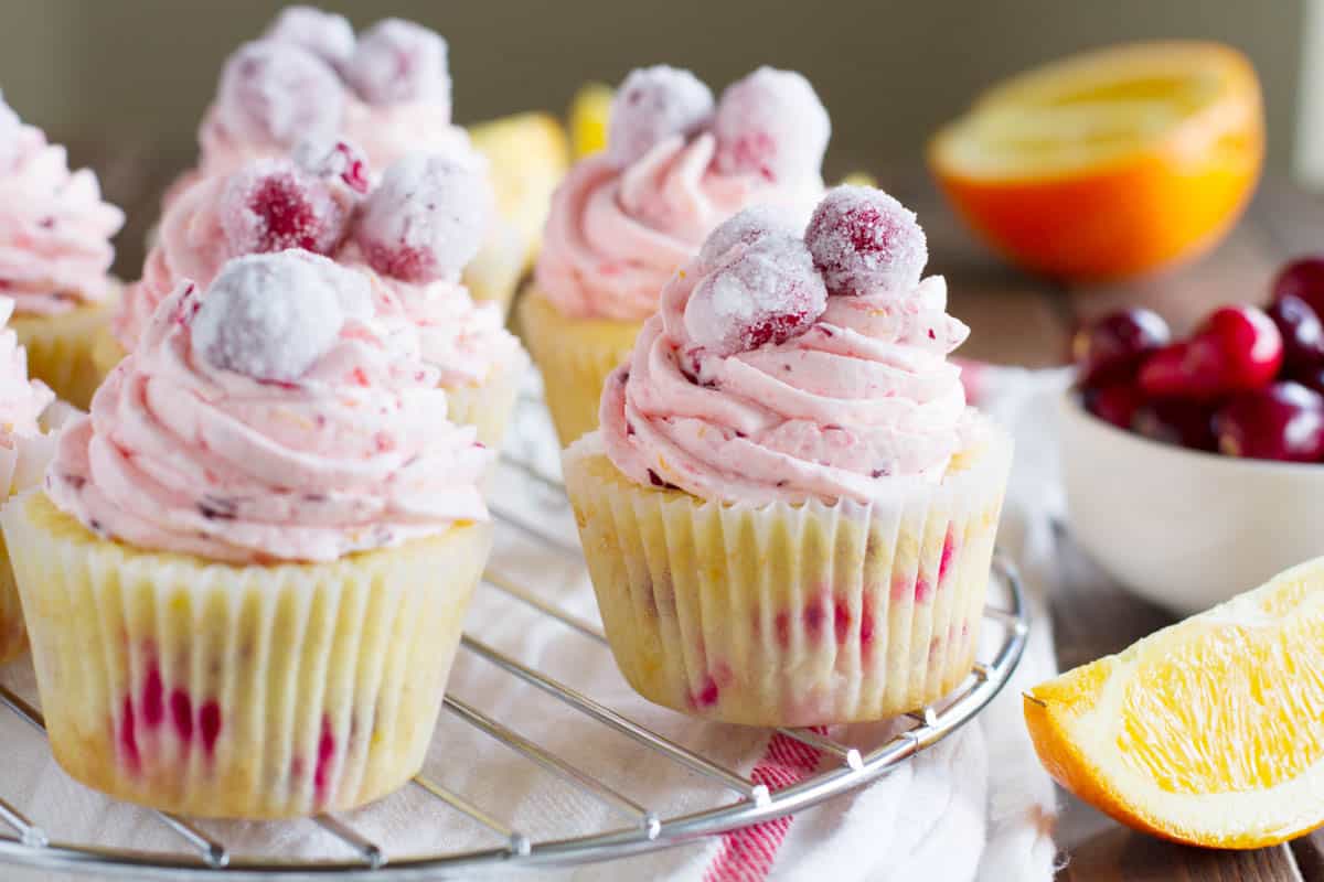 The perfect holiday cupcake, these Cranberry Orange Cupcakes are infused with orange zest and fresh cranberries, then topped with a silky cranberry orange buttercream. Make them even more festive by topping them with sugared cranberries. Cranberry orange cupcakes made with fresh cranberries and fresh oranges.