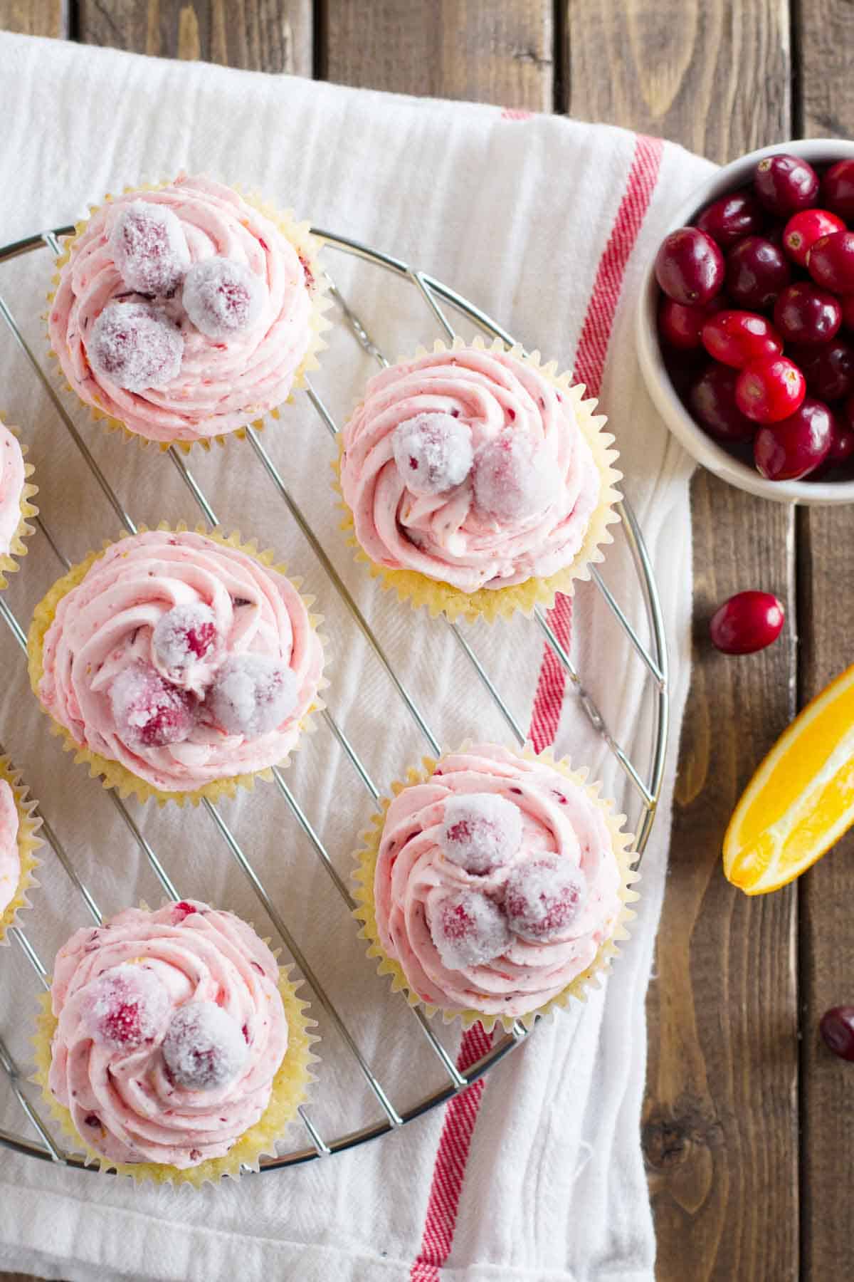 Cranberry orange cupcakes topped with fresh cranberry orange frosting and sugared cranberries.