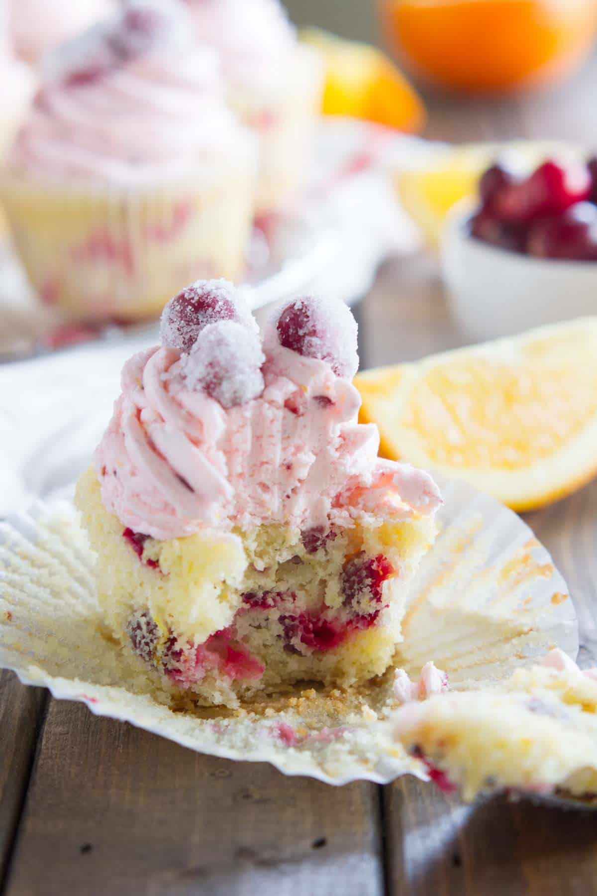 Cranberry orange cupcake with a bite taken from it.