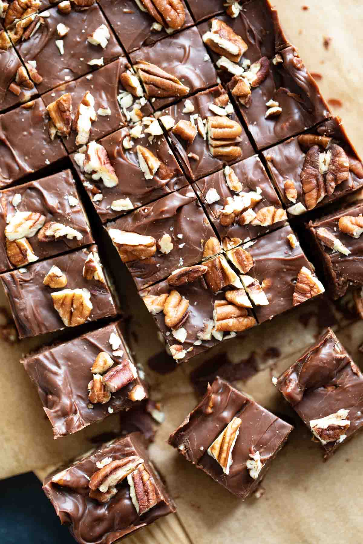 Easy fudge recipe cut into squares and topped with pecans.