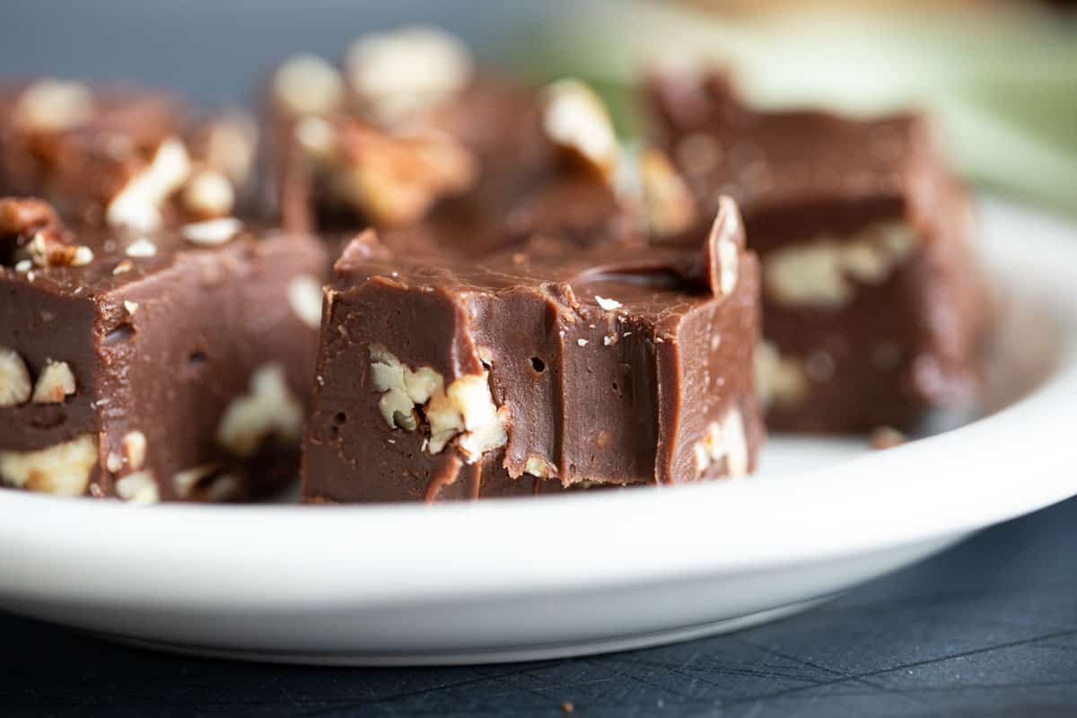 Chocolate pecan fudge with a bite taken from a piece.