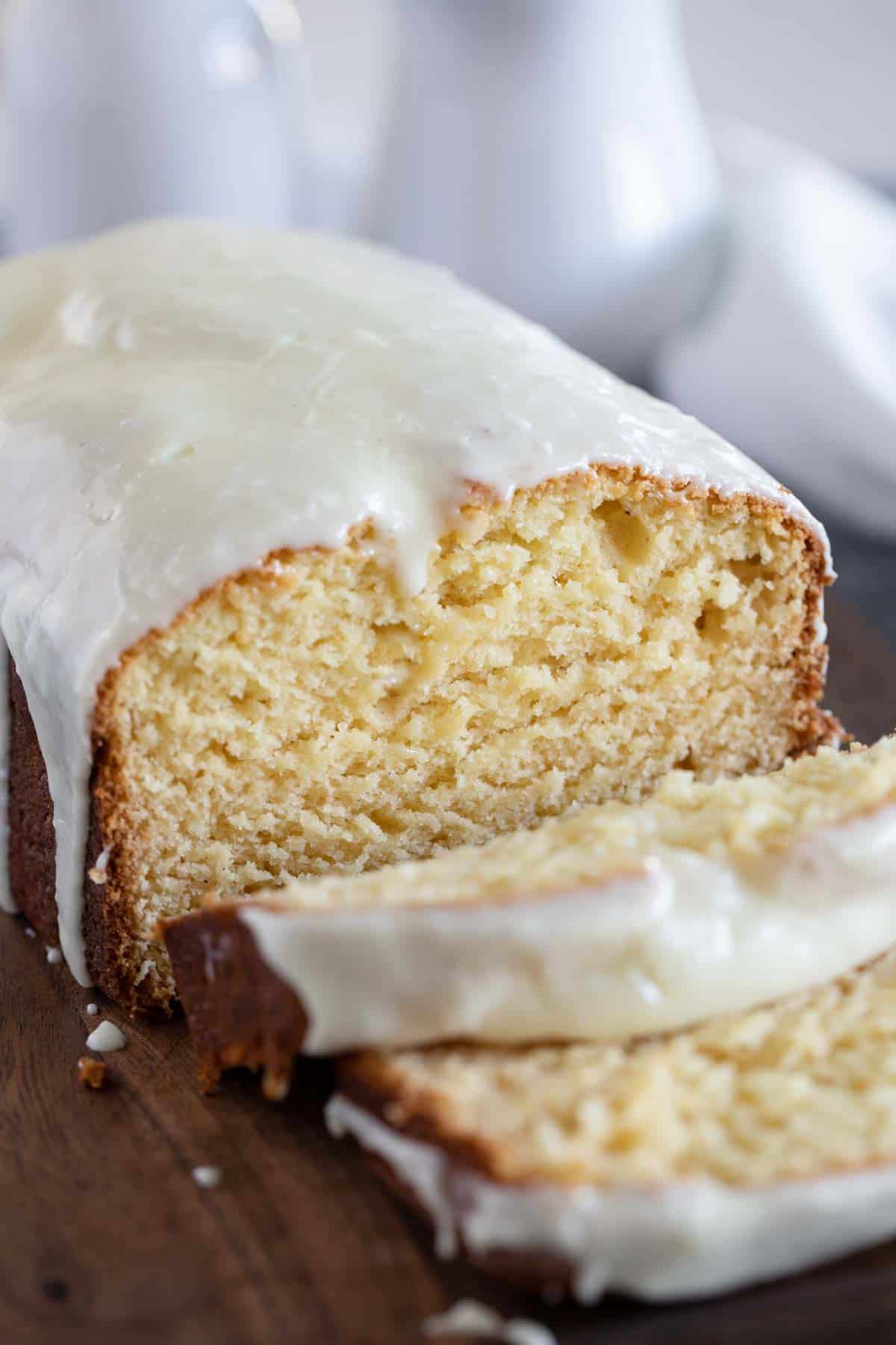 Loaf of eggnog bread with eggnog bread sliced on a cutting board.