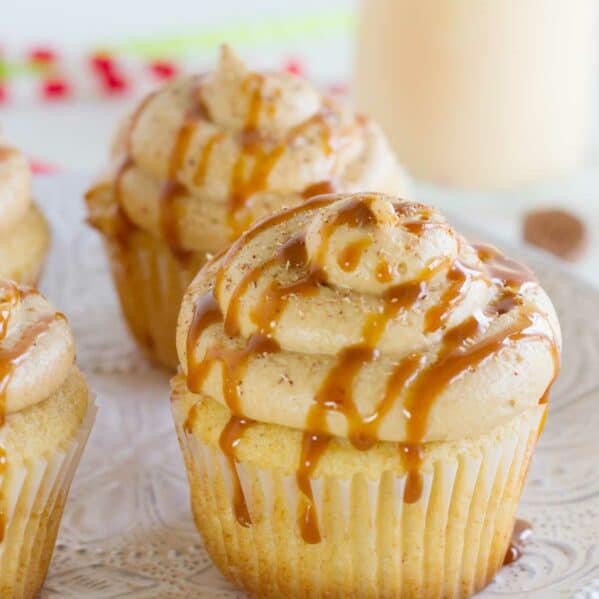 Eggnog cupcakes topped with caramel eggnog buttercream, caramel drizzle, and fresh nutmeg.
