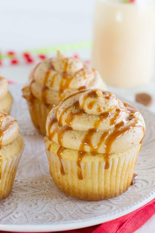 Eggnog cupcakes topped with caramel eggnog buttercream, caramel drizzle, and fresh nutmeg.