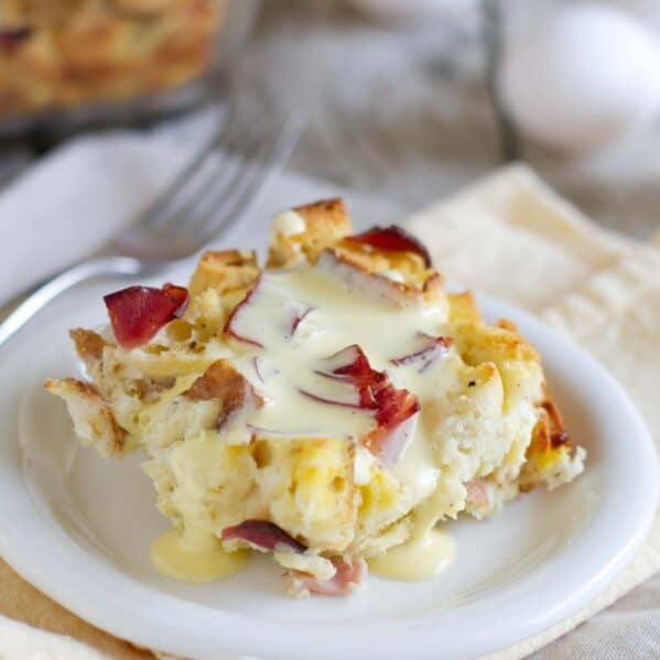 Piece of eggs benedict casserole with hollandaise sauce over the top.