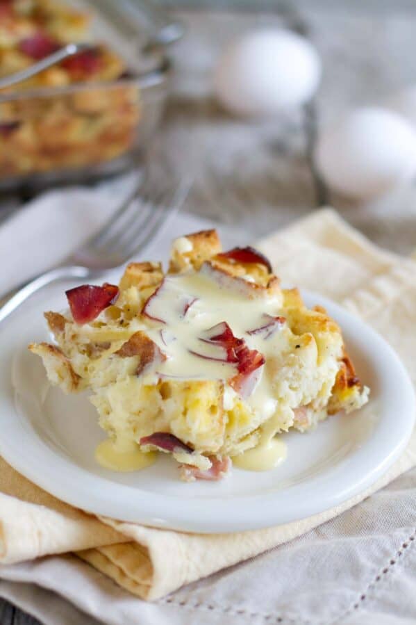 Piece of eggs benedict casserole with hollandaise sauce over the top.