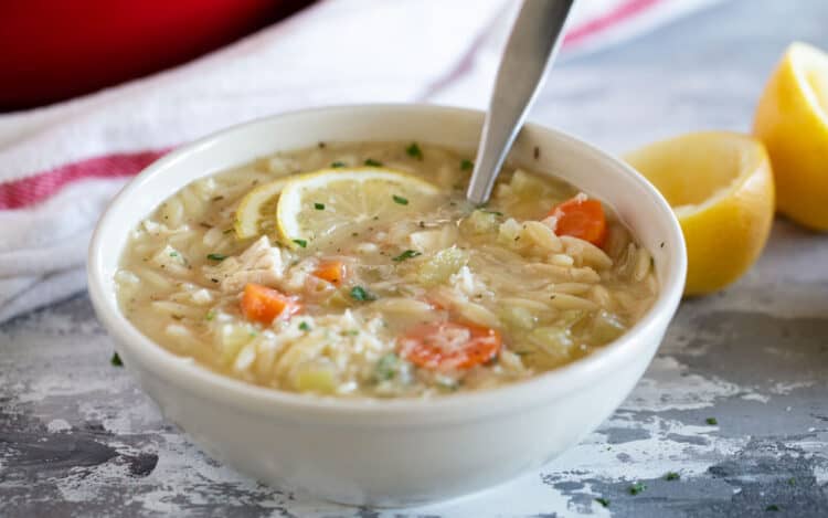 Bowl of Lemon Chicken Orzo Soup with carrots and celery.