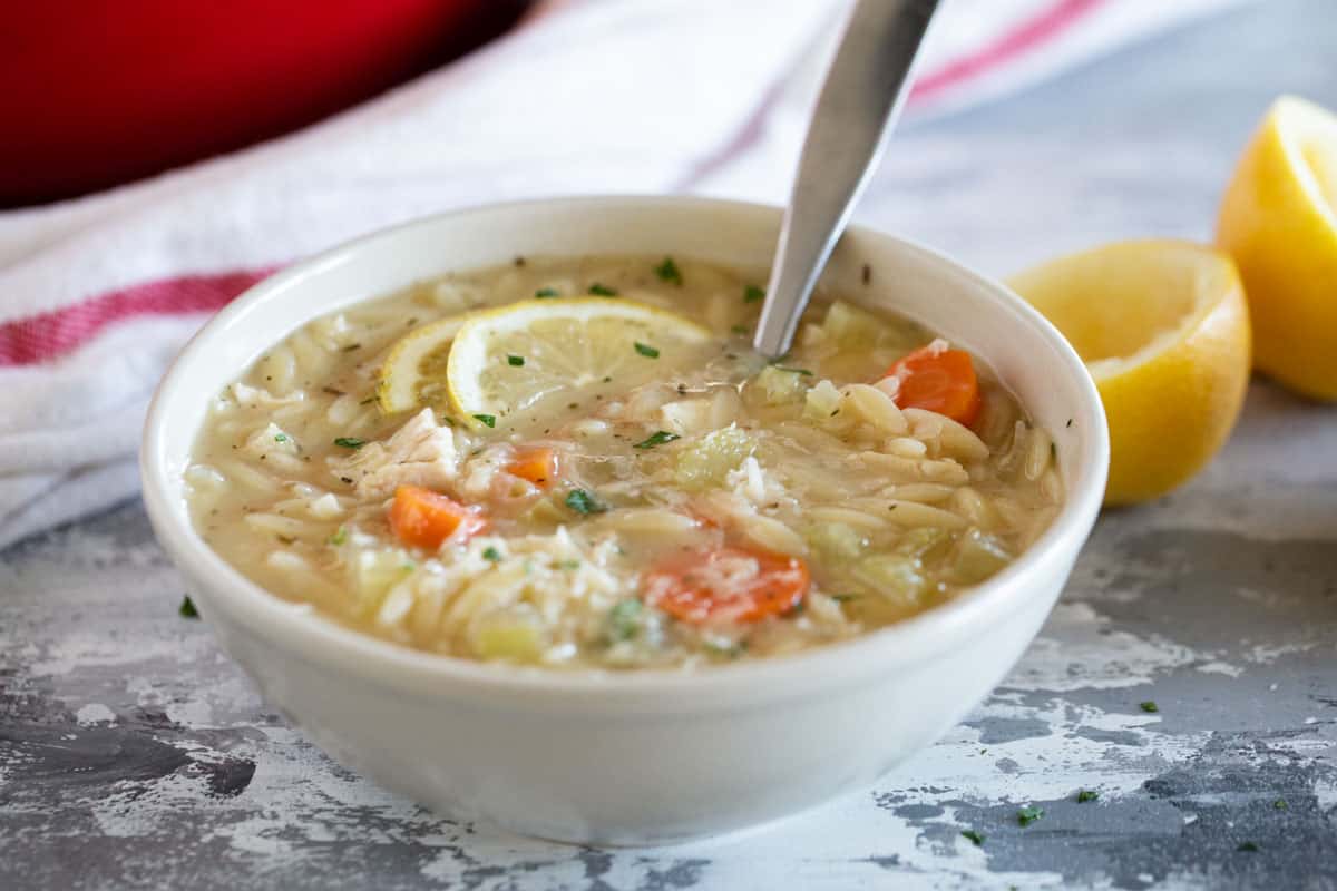 Bowl of Lemon Chicken Orzo Soup with carrots and celery.