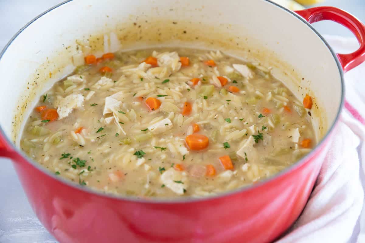Dutch oven filled with Lemon Chicken Orzo Soup.