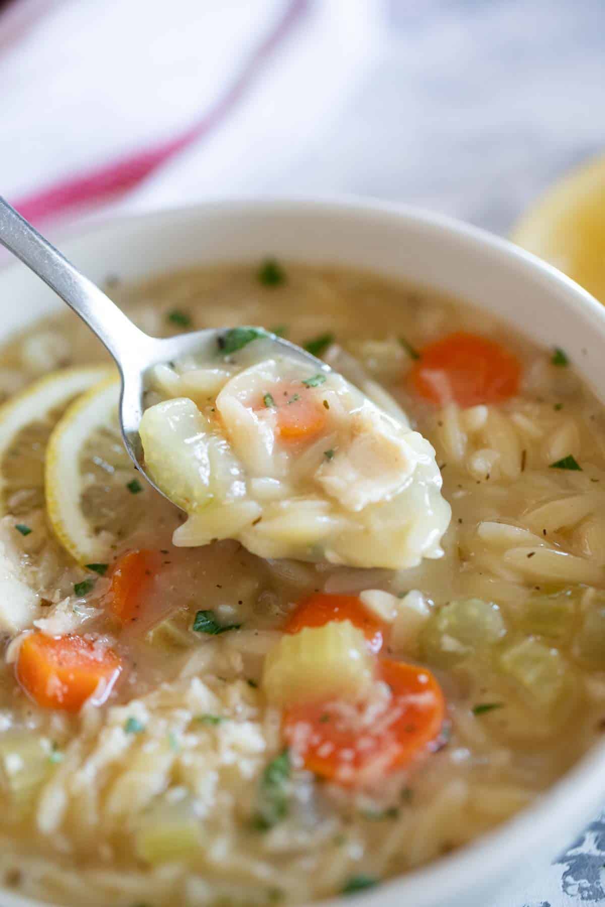 Bowl of Lemon Chicken Orzo Soup with a spoonful of soup over the bowl.