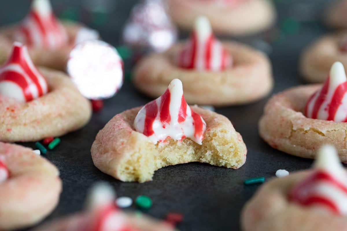 Cookie topped with a peppermint kiss on top with a bite taken from it.