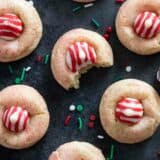 Peppermint Kiss Cookies with a bite taken from one of the cookies.