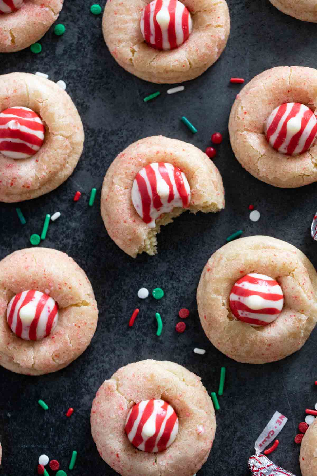 Peppermint Kiss Cookies with a bite taken from one of the cookies.