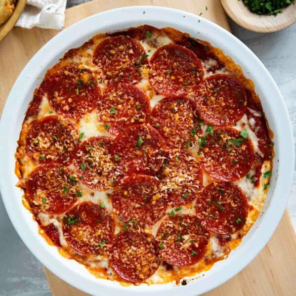 Pepperoni Pizza Dip topped with red pepper flakes and parsley.