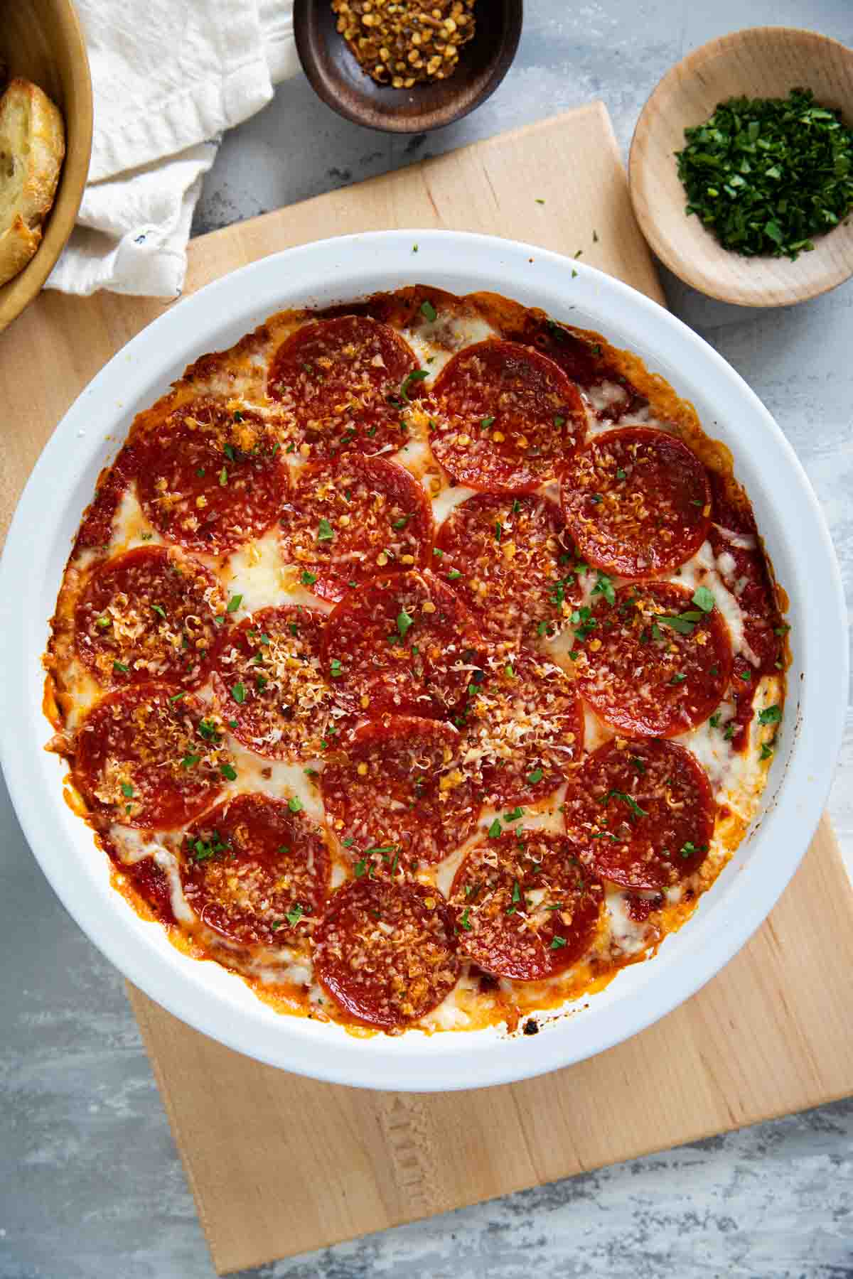 Pepperoni Pizza Dip topped with red pepper flakes and parsley.