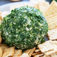 Southwest Cheese Ball covered in cilantro and covered by crackers.