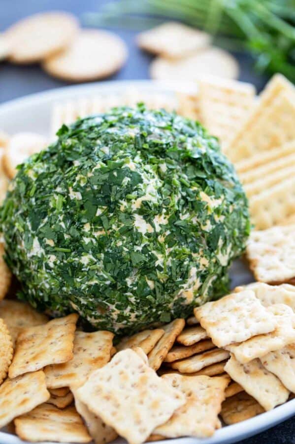 Southwest Cheese Ball covered in cilantro and covered by crackers.
