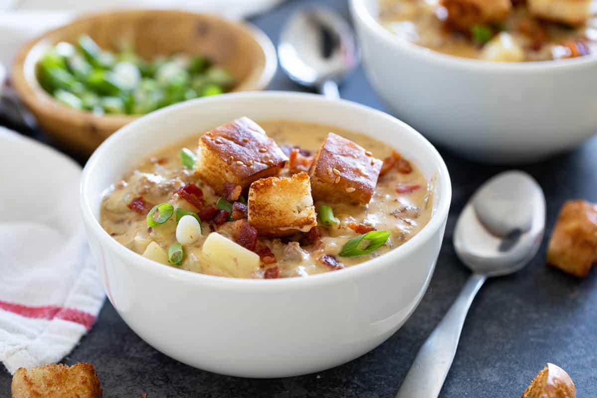 Bowl of bacon cheeseburger chowder topped with homemade croutons and crispy bacon.