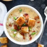Bowl of bacon cheeseburger chowder topped with croutons and bacon.