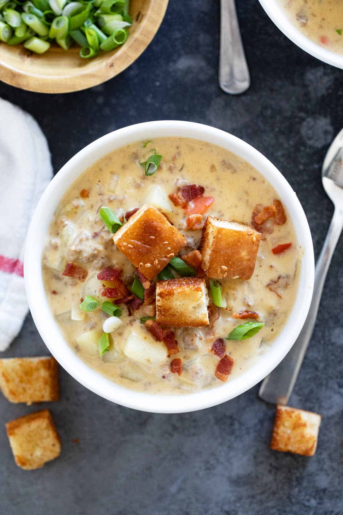 Bowl of bacon cheeseburger chowder topped with croutons and bacon.