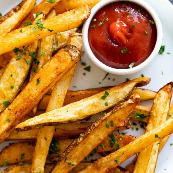 Baked French fries with ketchup.