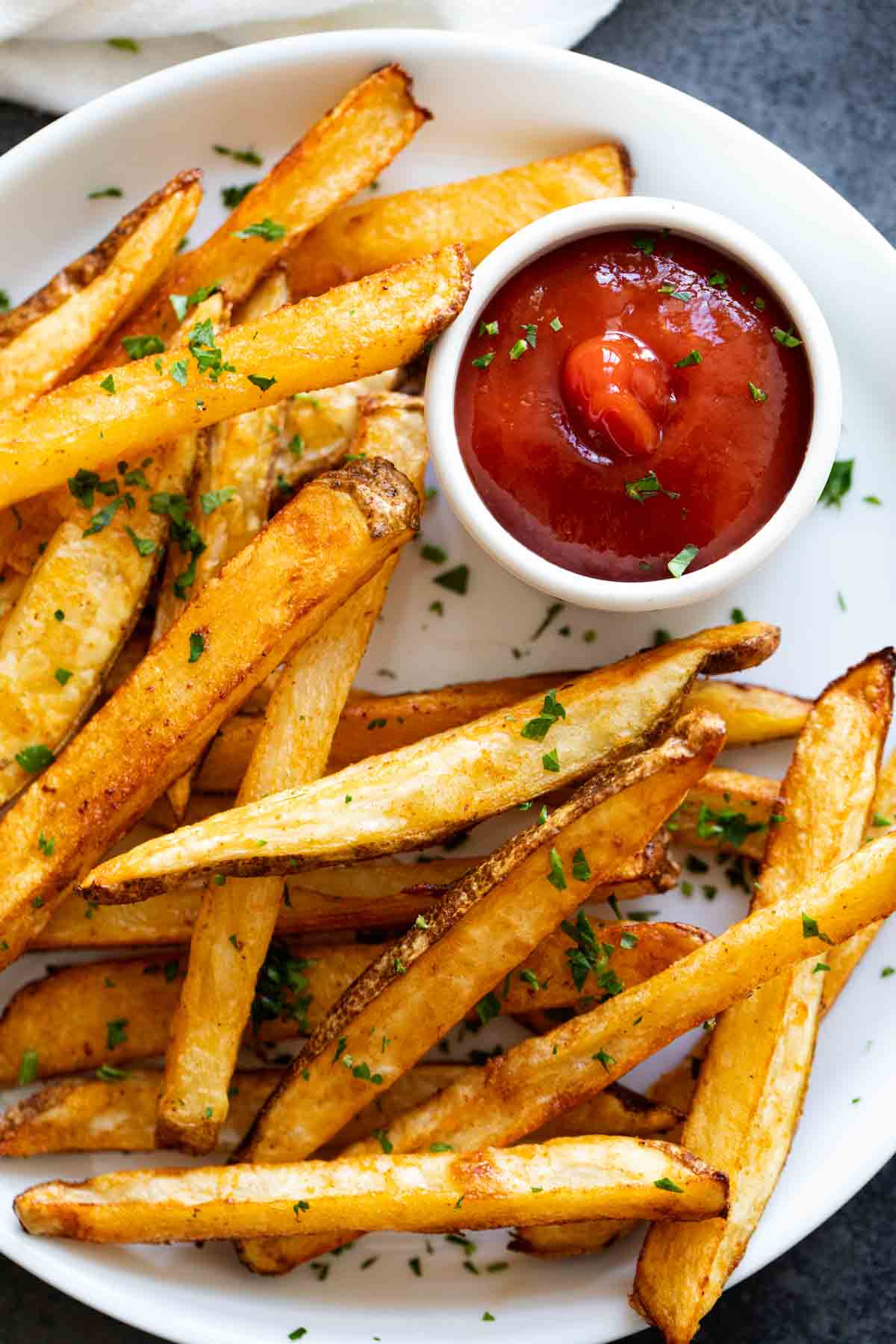 Baked French fries with ketchup.