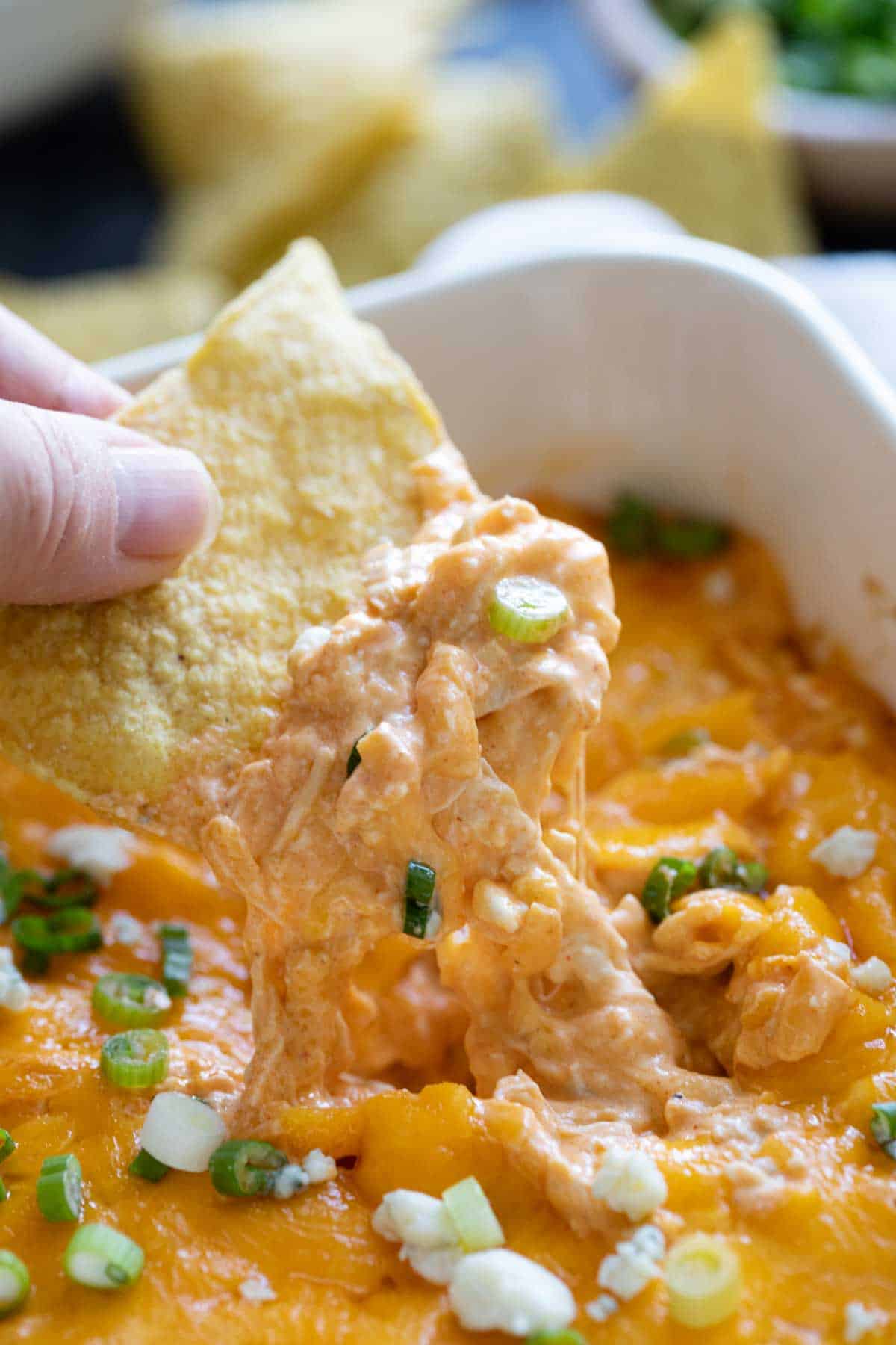 Dipping a tortilla chip into buffalo chicken dip.