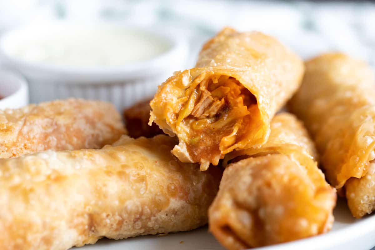 Buffalo Chicken Egg Rolls with a bite taken from one roll.