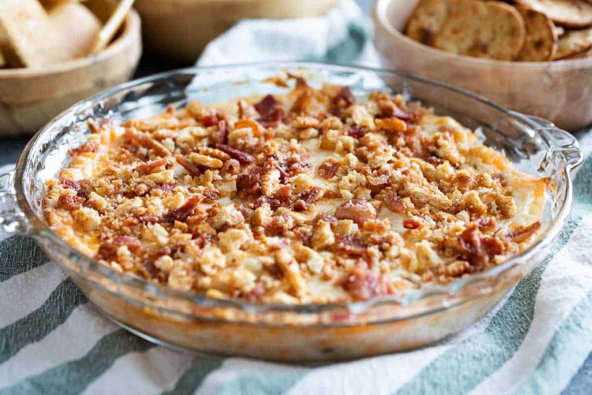 Cheesy Bacon Dip topped with crackers in a pie dish.