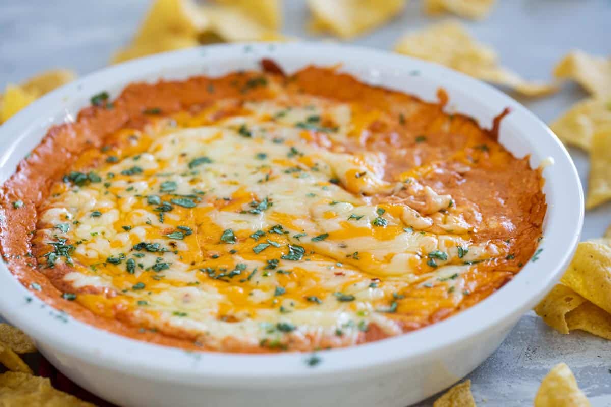 Dish with cheesy Mexican dip topped with cilantro.