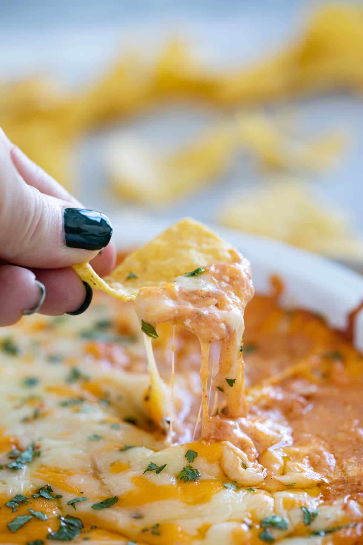 Chip with cheese pull from Cheesy Mexican Dip.