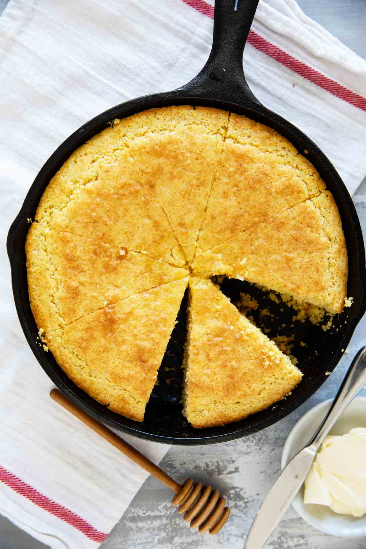 Cornbread cut into slices in a cast iron pan.