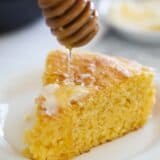 Drizzling honey on a slice of cornbread.