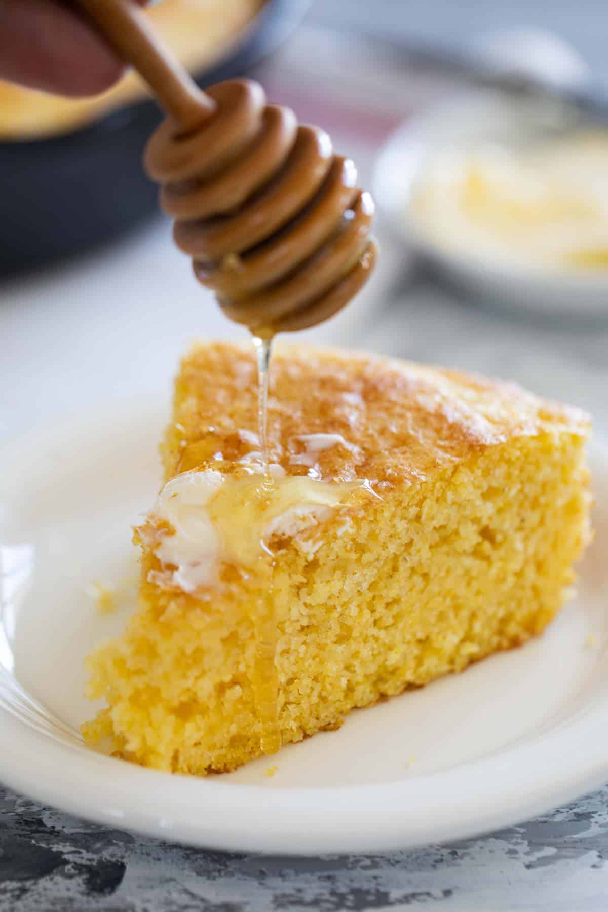 Drizzling honey on a slice of cornbread.