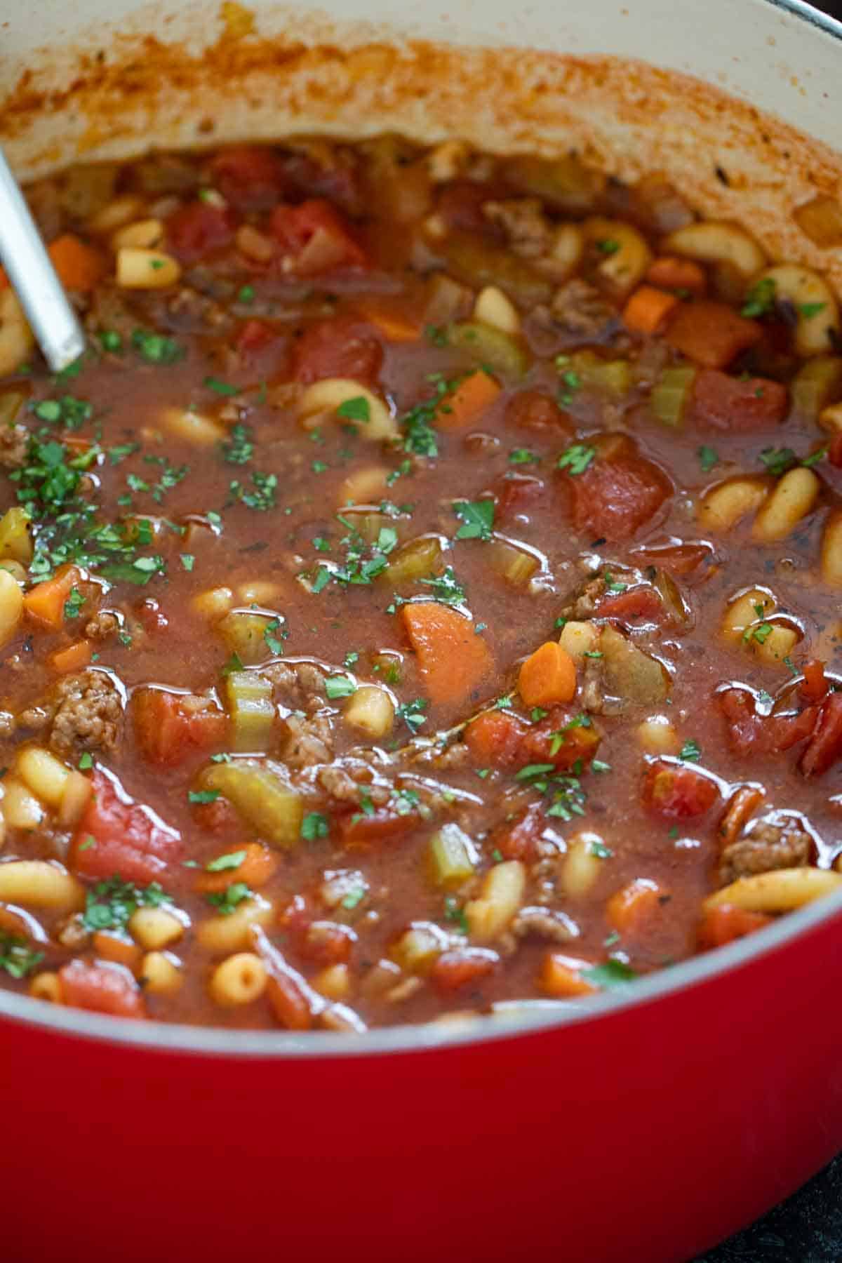 Pot filled with Hamburger Soup sprinkled with parsley.