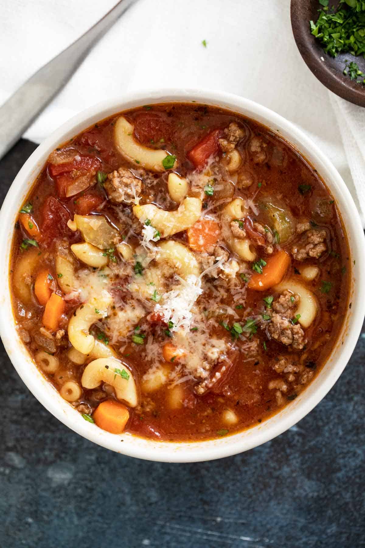 Bowl of hamburger soup topped with parmesan cheese.