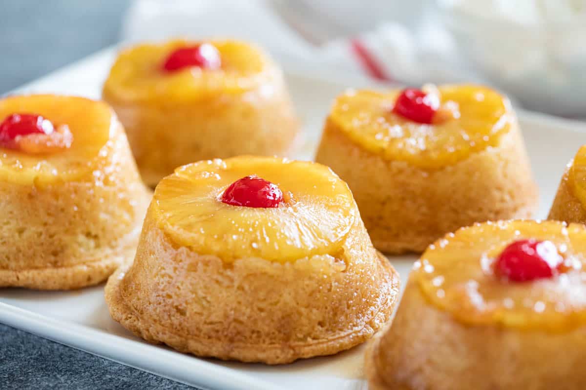 Pineapple Upside Down Cupcakes on a white serving plate.