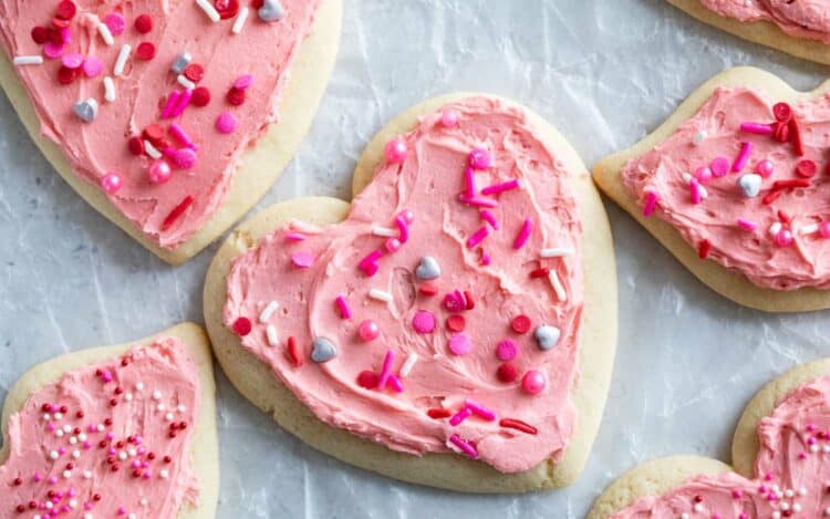 Valentine's Day Sugar Cookies shaped as hearts and lips, covered in pink buttercream.