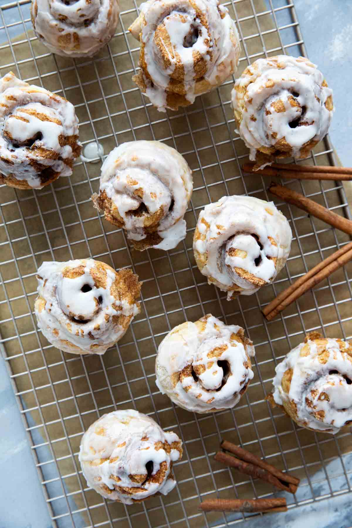 Cinnamon Roll Muffins drizzled with icing on a baking sheet.