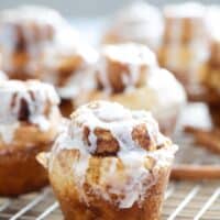 Cinnamon Roll Muffins with glaze on a baking sheet.