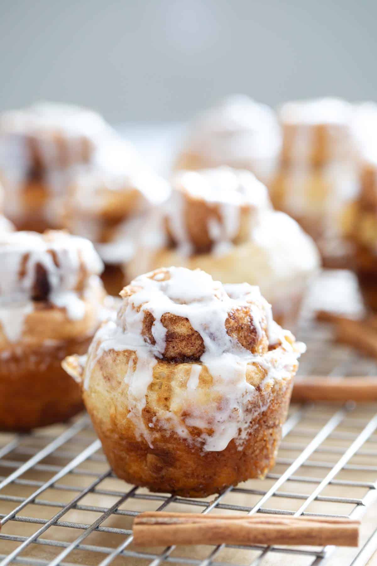 Cinnamon Roll Muffins with glaze on a baking sheet.